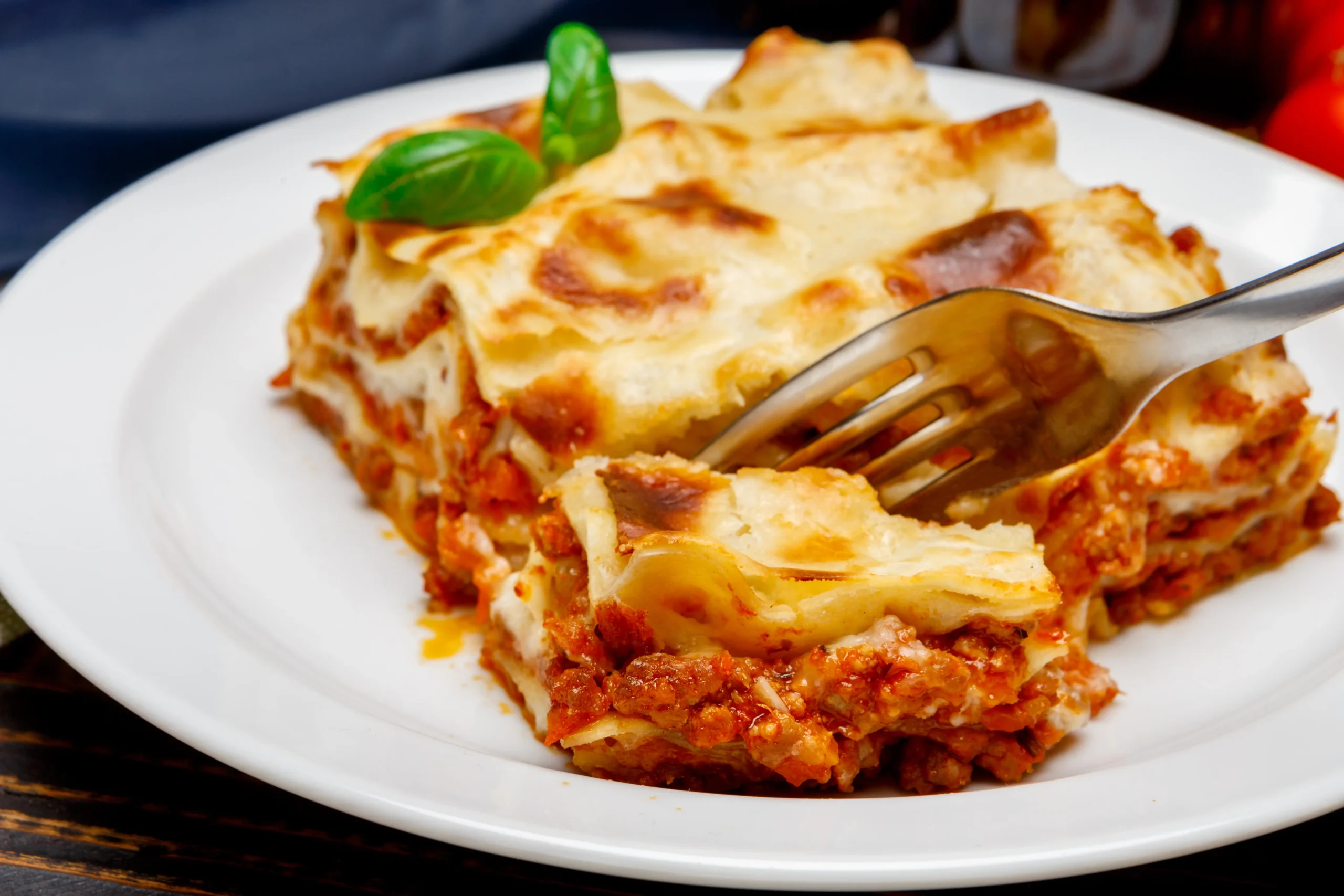 Cream cheese Lasagna Recipe with layers of noodles, ricotta, meat sauce, and melted mozzarella, served in a baking dish